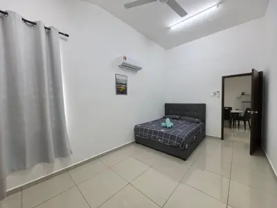 a bedroom with a bed and a mirror and a table at Padang Serai Taman Ria 61 in Padang Serai