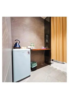 a kitchen with a refrigerator and a table at MI LE GARDEN Chalet in Sekincan
