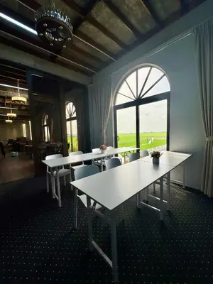 a room with tables and chairs and a large window at MI LE GARDEN Chalet in Sekincan