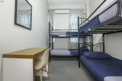 a room with two bunk beds and a desk at Bed Station Guest House in Tanah Rata