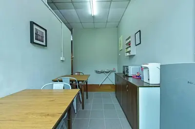 a room with a cafeteria with tables and chairs at Bed Station Guest House in Tanah Rata