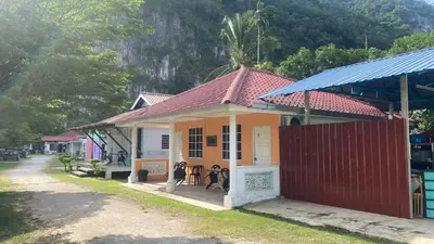 a small yellow house with a red roof at Capital O 91189 Chalet Asyuk Maju in Baling