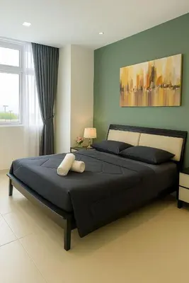 a bedroom with a large bed with a black bedspread at 2 Connecting Room, Riverine Diamond in Gua Sai