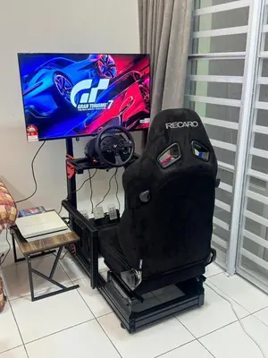 a gaming chair sitting in front of a tv at Ayaan Gaming Home 2 Experience Real Life Simulator Racing Games in Tanah Rata