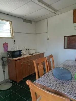 a dining room with a table and a microwave at Homestay Mariah in Ipoh
