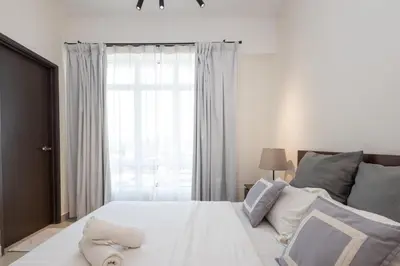 a bedroom with a large white bed with a window at Simple Bali l Projector l Netflix l 2 parking in Ipoh
