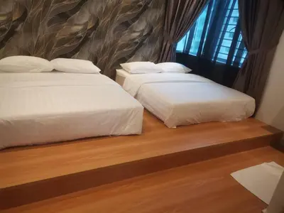 two beds sitting next to each other in a bedroom at Adik Aisyah black forest luxury cameron homestay in Tanah Rata