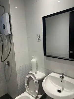 a bathroom with a toilet and a sink and a mirror at Adik Aisyah black forest luxury cameron homestay in Tanah Rata