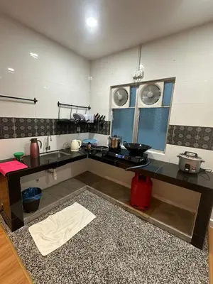 a kitchen with a black counter top in a room at Adik Aisyah black forest luxury cameron homestay in Tanah Rata