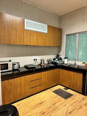 a kitchen with wooden cabinets and a counter top at Ayaan Snookers House 2 at Quintet Cameron Highland in Tanah Rata