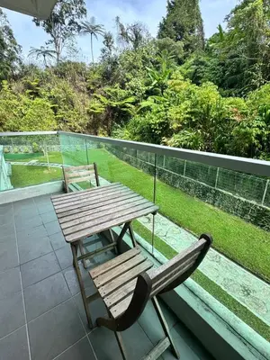 a wooden table and a chair sitting on a balcony at Ayaan Snookers House 2 at Quintet Cameron Highland in Tanah Rata