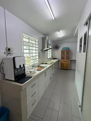 a large kitchen with white cabinets and a microwave at DND Homestay Sitiawan in Sitiawan