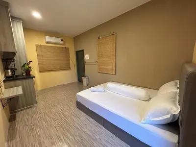 a bedroom with a bed with white sheets and pillows at Homestay Kenangan Kati Kuala Kangsar in Kuala Kangsar