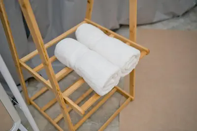 a stack of white towels on a wooden chair at Singah in Bukit Mertajam