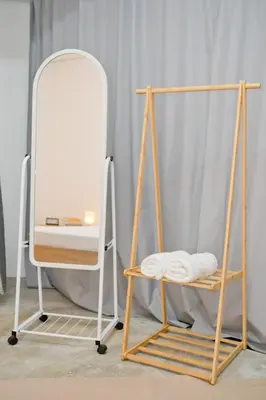 a mirror and a chair next to a towel rack at Singah in Bukit Mertajam