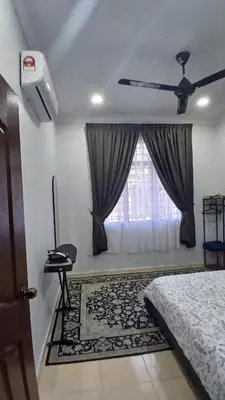 a bedroom with a ceiling fan and a window at Homestay Makyu in Kuala Kangsar