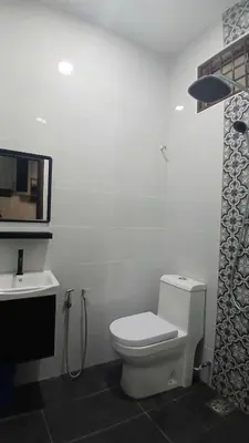a white bathroom with a toilet and a sink at Homestay Makyu in Kuala Kangsar