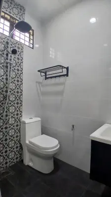 a white bathroom with a toilet and a sink at Homestay Makyu in Kuala Kangsar