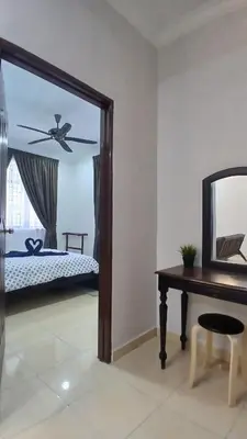 a bedroom with a bed and a mirror and a desk at Homestay Makyu in Kuala Kangsar