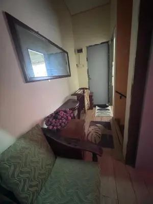 a room with a table and a couch and a window at Homestay Pangkor Ann in Pangkor