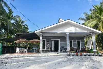 a small white house with a porch and patio at Homestay Omah D'Desa with pool in Kampong Telok Ru