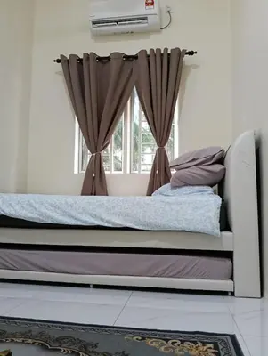 a bed in a room with a window at Homestay Omah D'Desa with pool in Kampong Telok Ru
