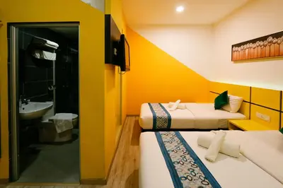 a room with two beds and a bathroom with a sink at Golden Roof Hotel Sunway Ipoh in Ipoh
