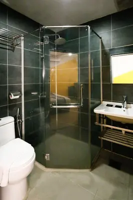 a bathroom with a shower and a toilet and a sink at Golden Roof Hotel Sunway Ipoh in Ipoh