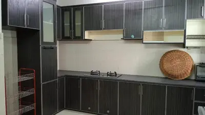 a kitchen with dark wood cabinets and a sink at Eyna Homestay in Sitiawan