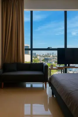 a living room with a couch and a large window at 2 Connecting Room, Kozi Square, 9A & 9B in Gua Sai