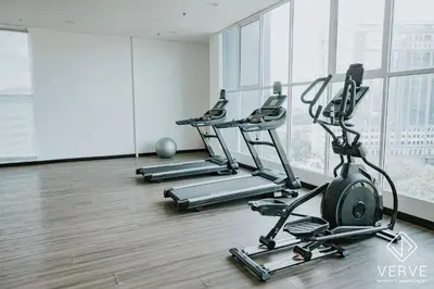 a gym with cardio equipment in a room with windows at Ipoh Town ICC Premium Suites by Verve 2B2B in Ipoh