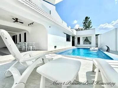 a white house with a swimming pool and white chairs at Mars1 Private Pool Homestay in Ipoh