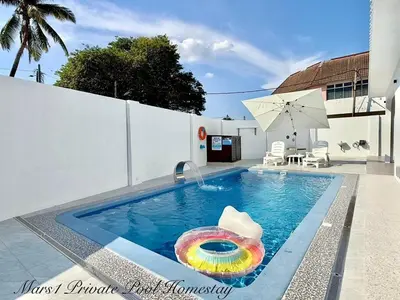 a swimming pool with a colorful umbrella and an inflatable at Mars1 Private Pool Homestay in Ipoh