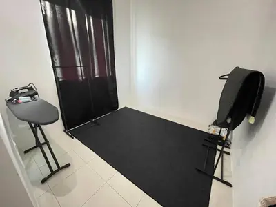 a room with a chair and a black door at Nazana Homestay in Batu Gajah