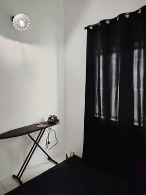 a room with a table and a black curtain at Nazana Homestay in Batu Gajah