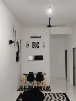 a dining room with a table and four chairs at Nazana Homestay in Batu Gajah