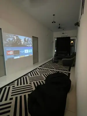 a living room with a flat screen tv and a couch at Nazana Homestay in Batu Gajah