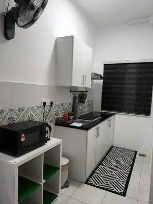 a kitchen with white cabinets and a black and white floor at Apartment In Ipoh, City View in Ipoh