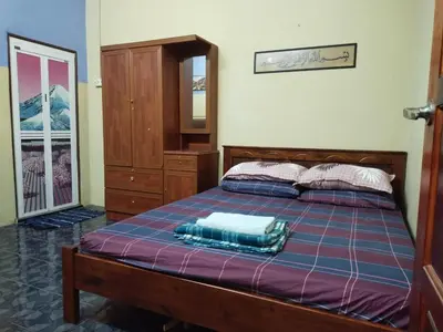 a bedroom with a bed and a dresser at Sacha Semarak in Baling