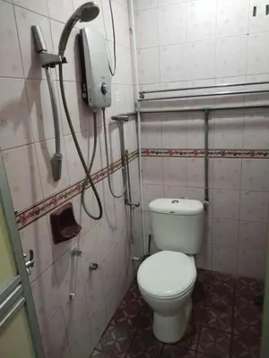 a bathroom with a toilet and a phone on the wall at Sacha Semarak in Baling