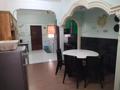 a kitchen and dining room with a table and chairs at Sacha Semarak in Baling