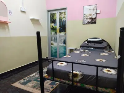a bedroom with a bed with flowers on it at Sacha Semarak in Baling