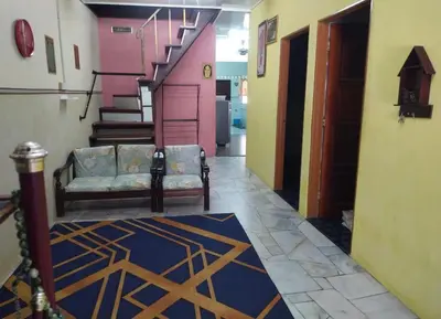 a hallway with a couch and stairs in a building at Sacha Semarak in Baling