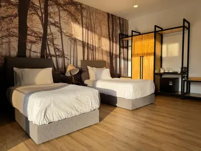 a bedroom with two beds and a painting on the wall at Jef Hill Villa Ipoh in Kampong Batu Lapan
