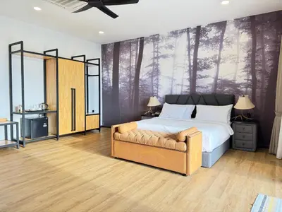 a bedroom with a bed and a chair and trees mural at Jef Hill Villa Ipoh in Kampong Batu Lapan