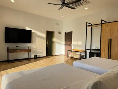 a bedroom with two beds and a flat screen tv at Jef Hill Villa Ipoh in Kampong Batu Lapan
