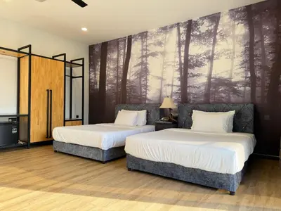 two beds in a room with a mural of trees at Jef Hill Villa Ipoh in Kampong Batu Lapan