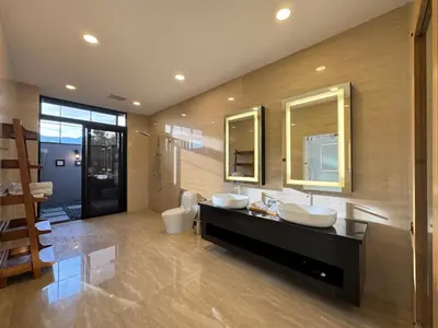 a bathroom with two sinks and two mirrors at Jef Hill Villa Ipoh in Kampong Batu Lapan