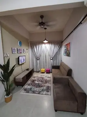 a living room with a couch and a table at Serra Homestay at Apartment Bukit Permata, Lumut in Lumut