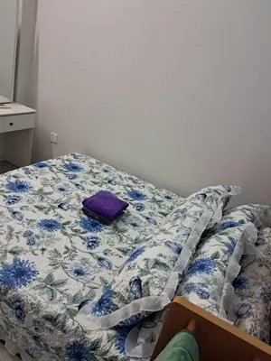 an unmade bed with a purple pillow on it at Serra Homestay at Apartment Bukit Permata, Lumut in Lumut